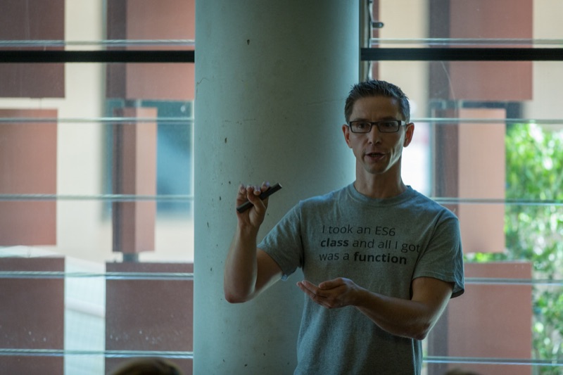 Duncan presenting with a clicker in a tee reading I took an ES6 class and all I got was a function.