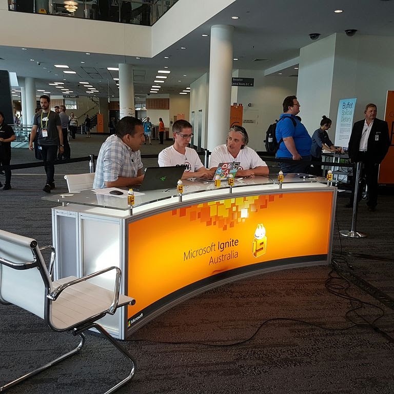 Three people interviewing at the SSW TV booth desk.