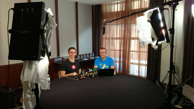 Duncan and Lars Klint at a round table under studio lights in a hotel room.